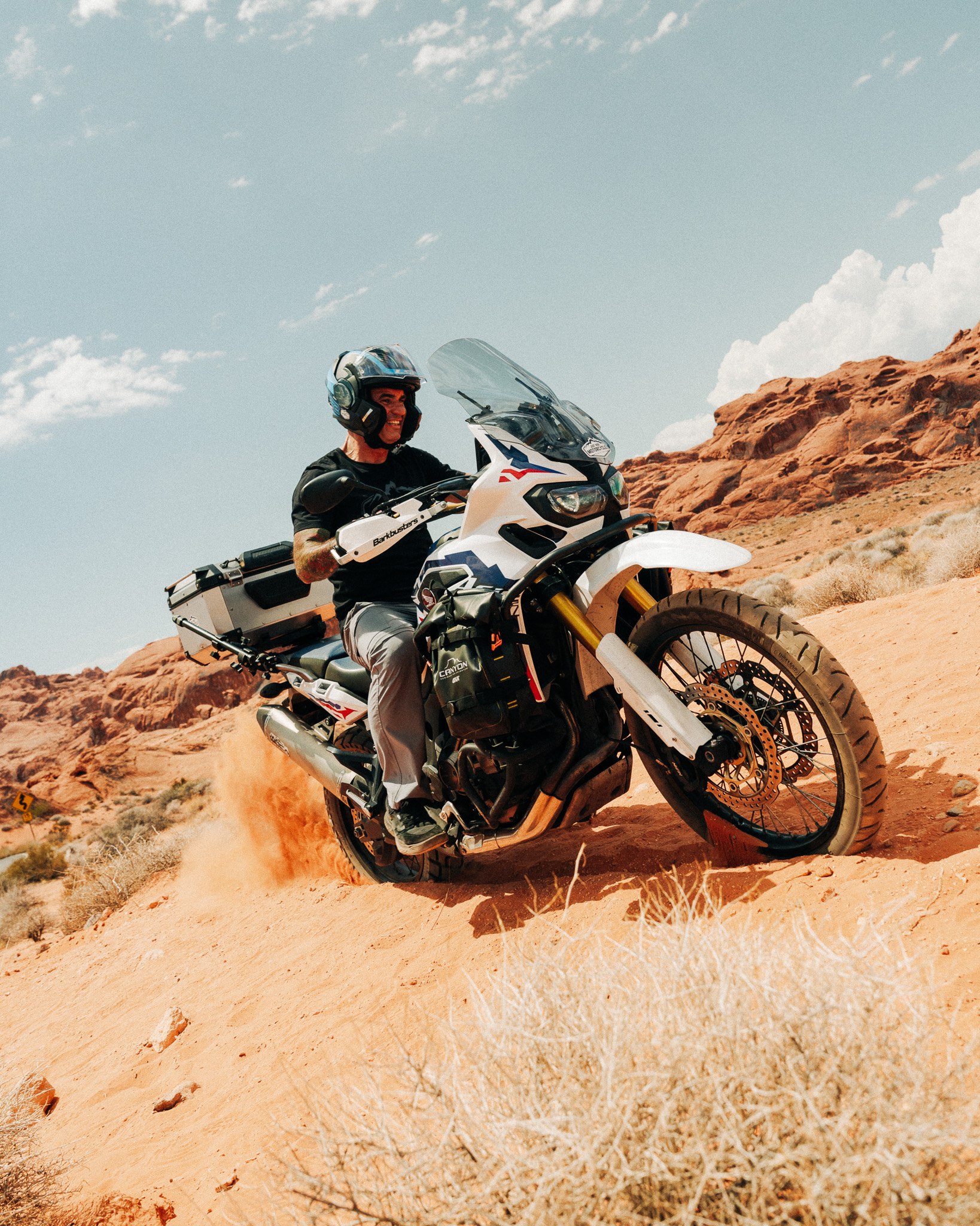 Rider kicking up dust on a desert off-road trail