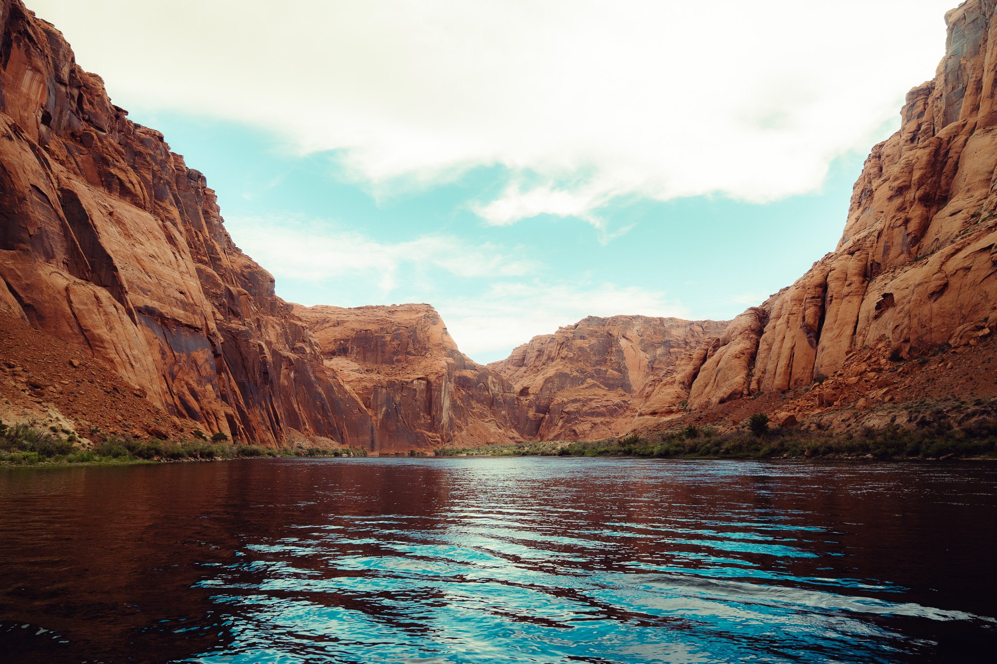 Boating on the Colorado River through a red rock canyon