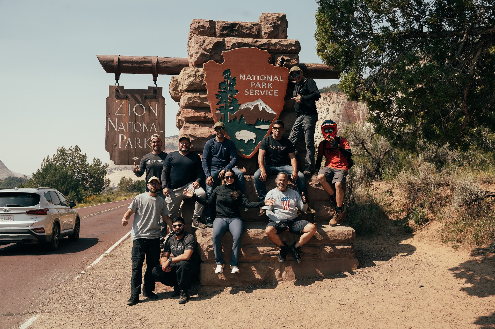 Just Ride group at the Zion National Park entrance sign