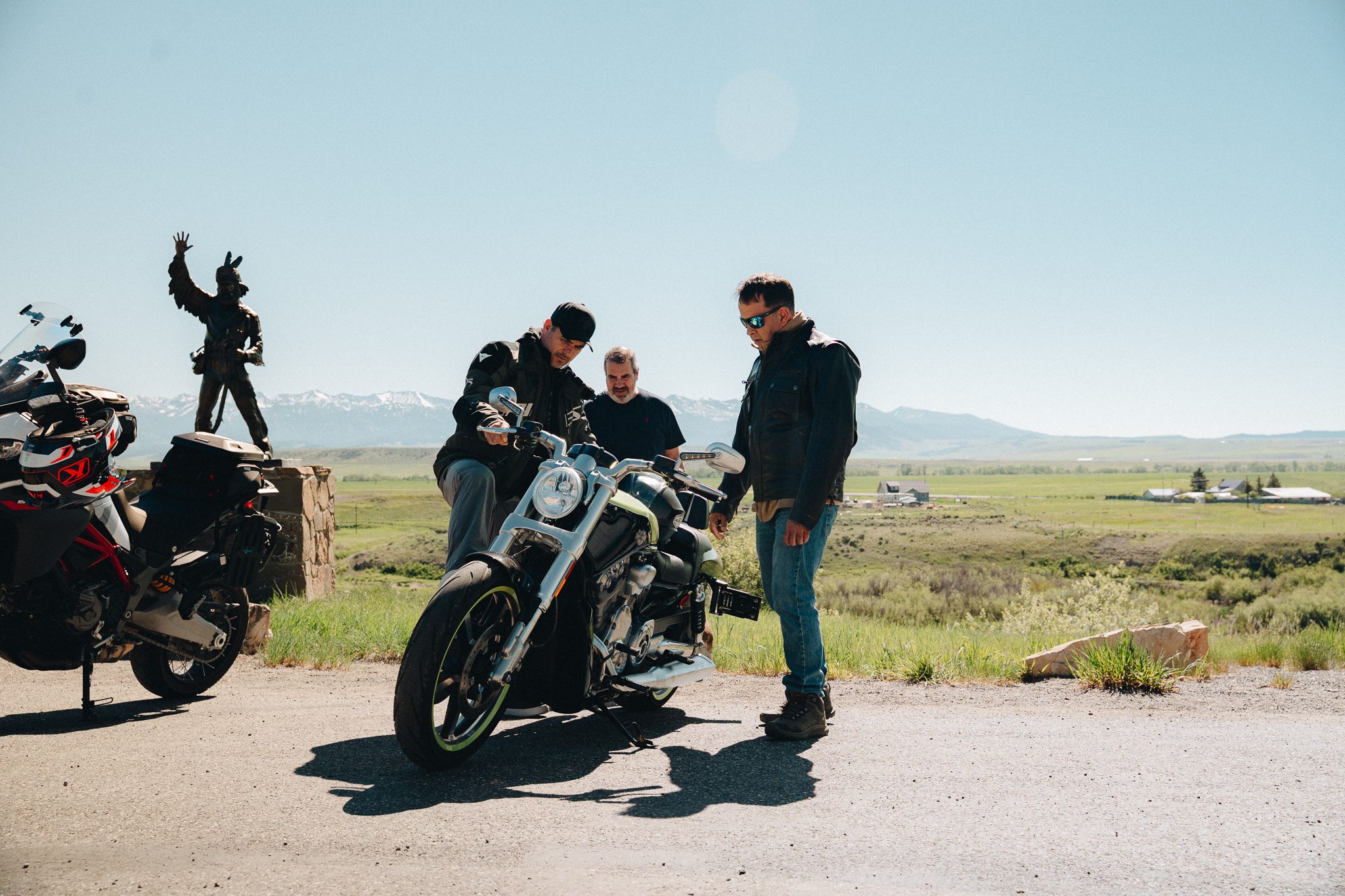 Riders comparing motorcycles at a scenic overlook in Montana