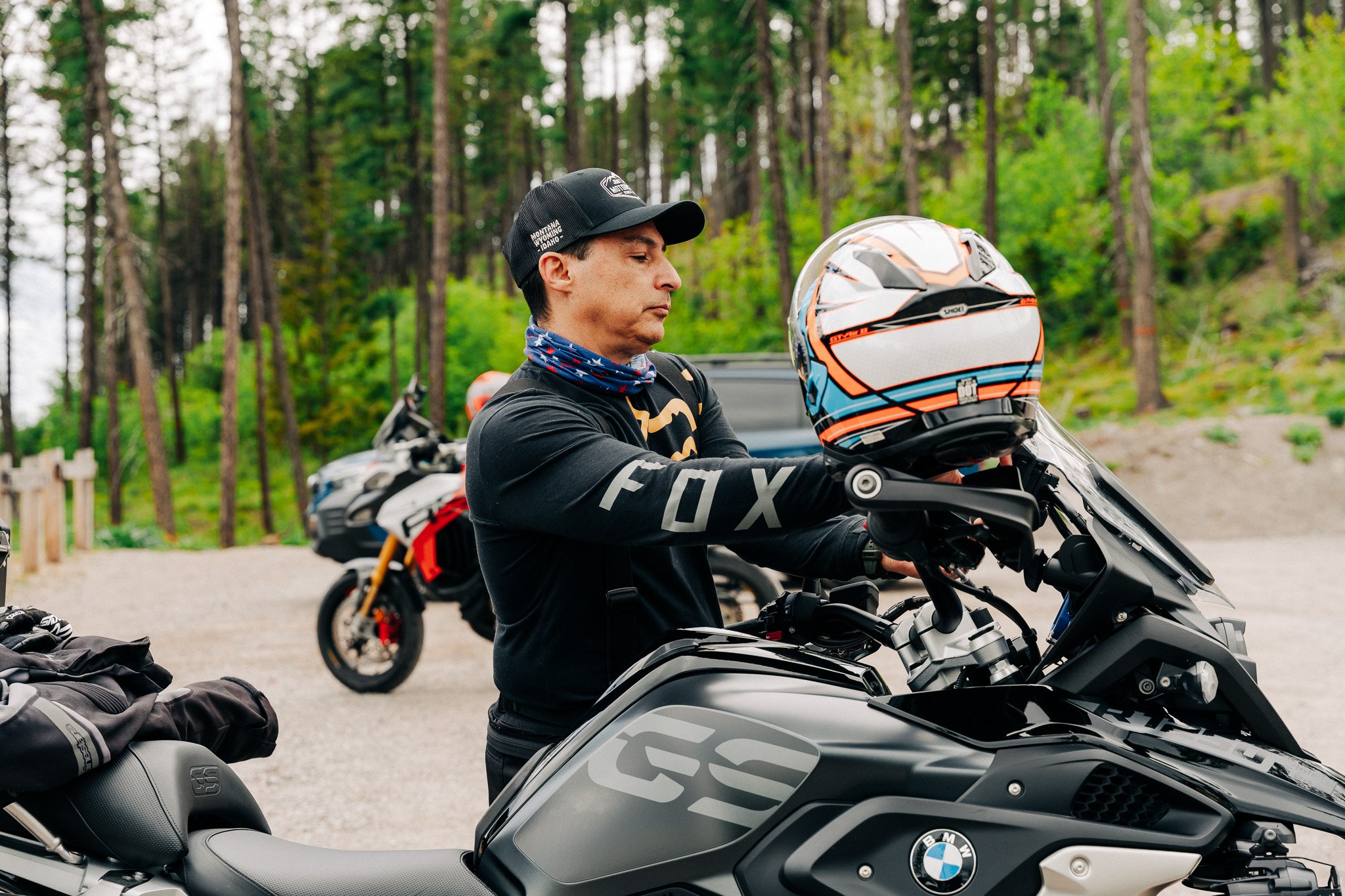 Riders resting beside their motorcycles in the forest