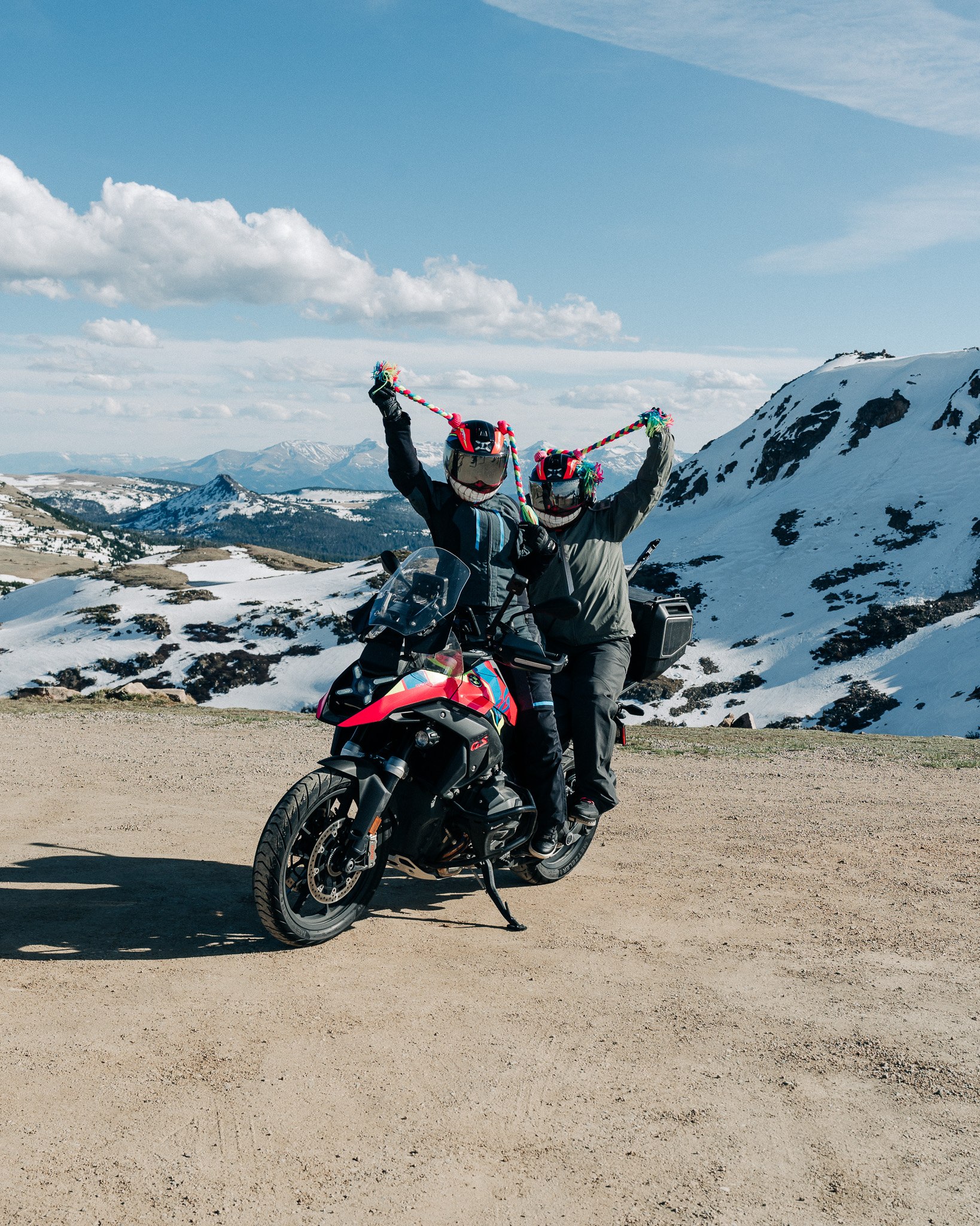 Riders celebrating at a mountain summit